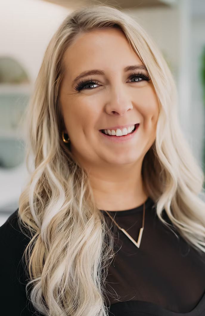 A woman with blonde hair and a nose ring is smiling for the camera.