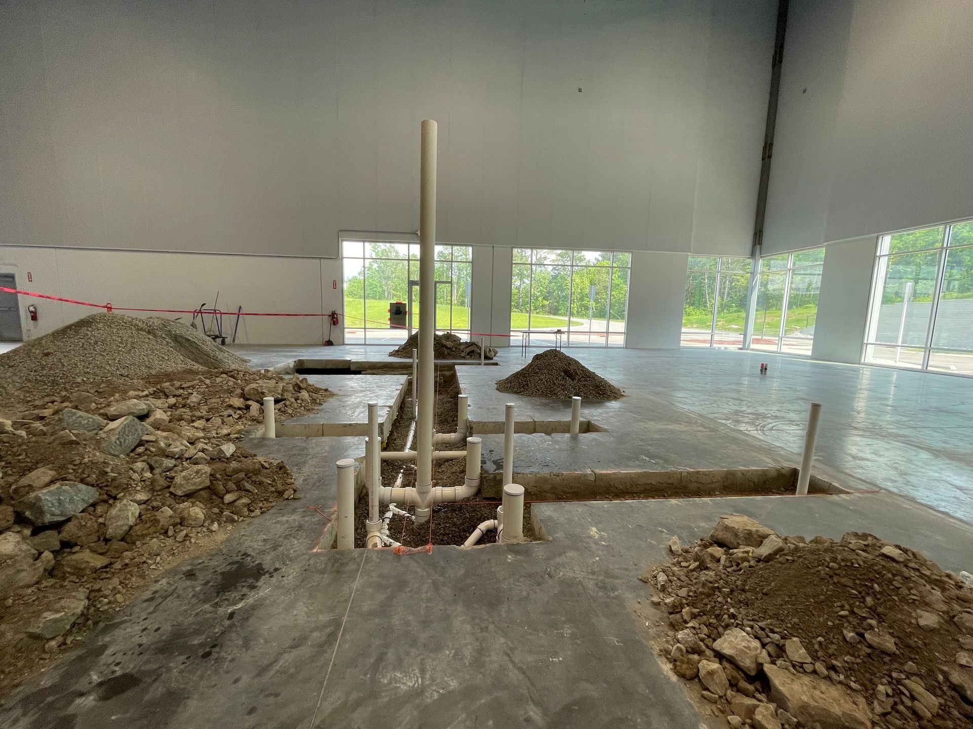 A large building under construction with a lot of pipes in the ground.