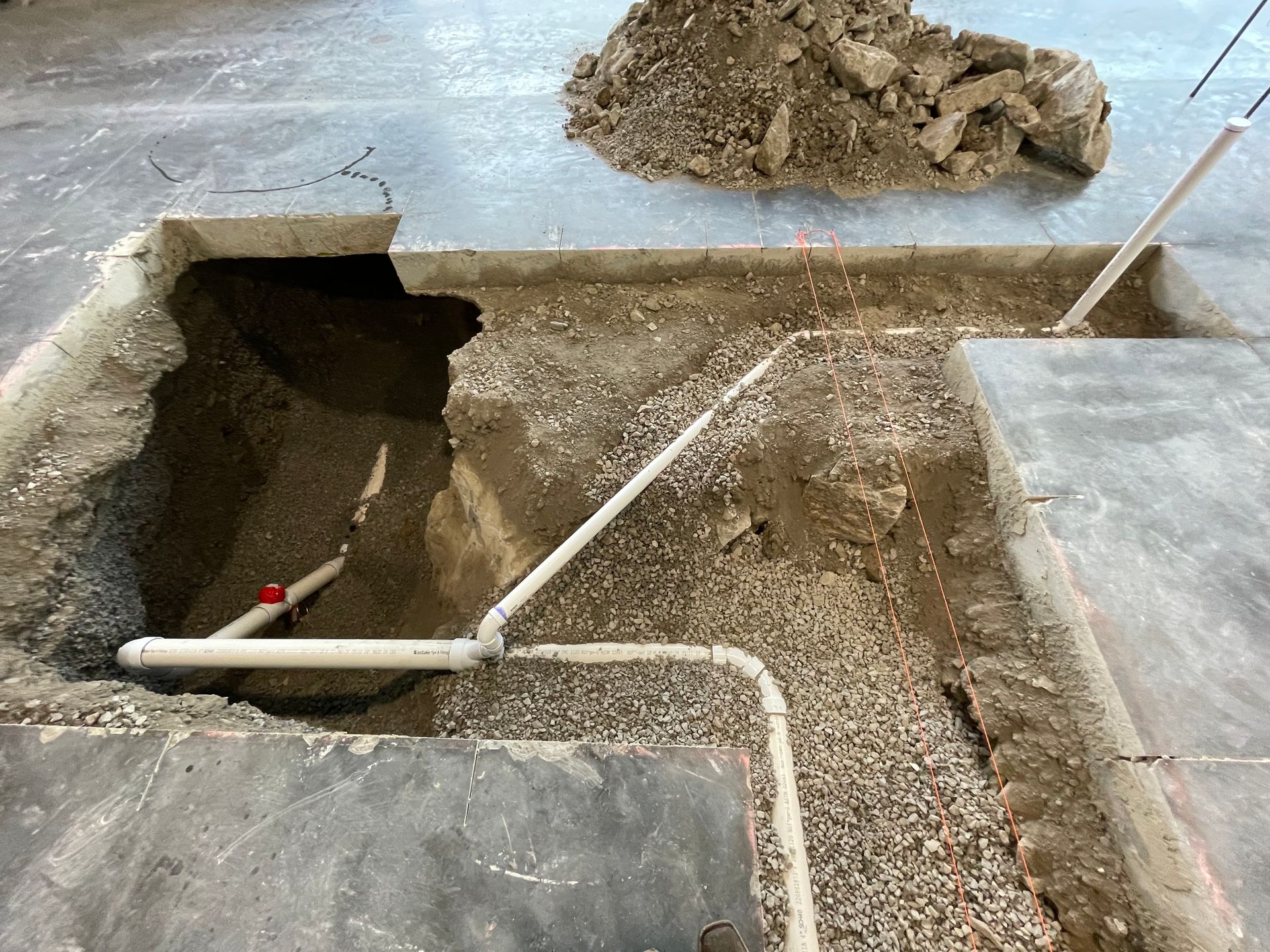 A hole in the ground with a pipe in it.