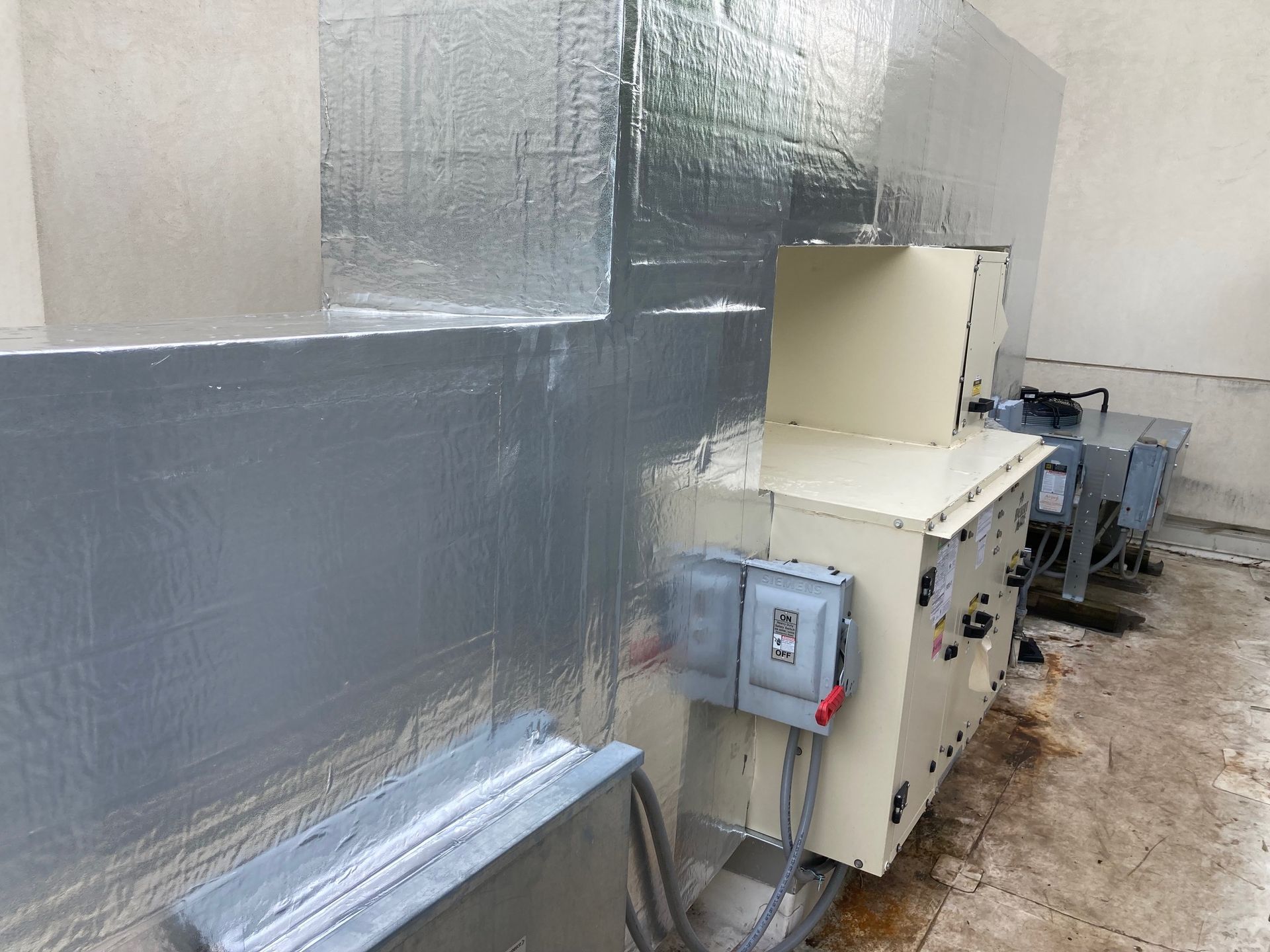 A machine is sitting in a room with a lot of wires coming out of it.