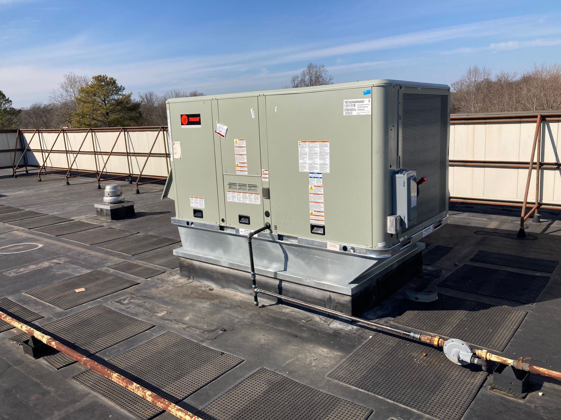 A large air conditioner is sitting on top of a roof.