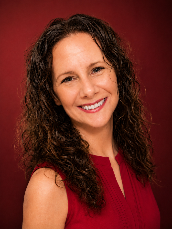Joi Dupre, owner of Motivity with Joi,
licensed massage therapist and movement professional, smiling in a red blouse.