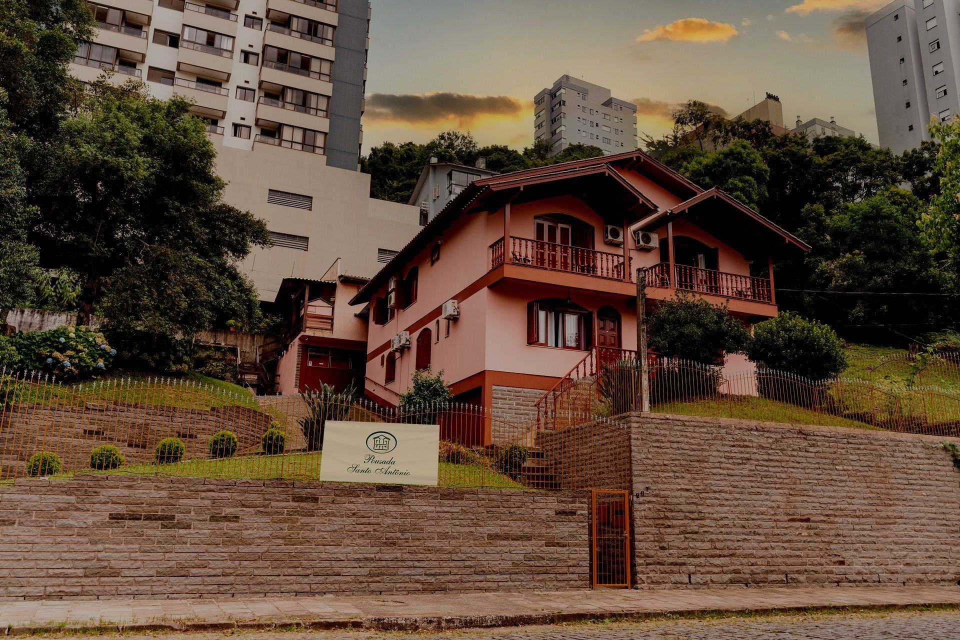 Uma grande casa rosa com escadas que levam até ela- Pousada Santo Antônio