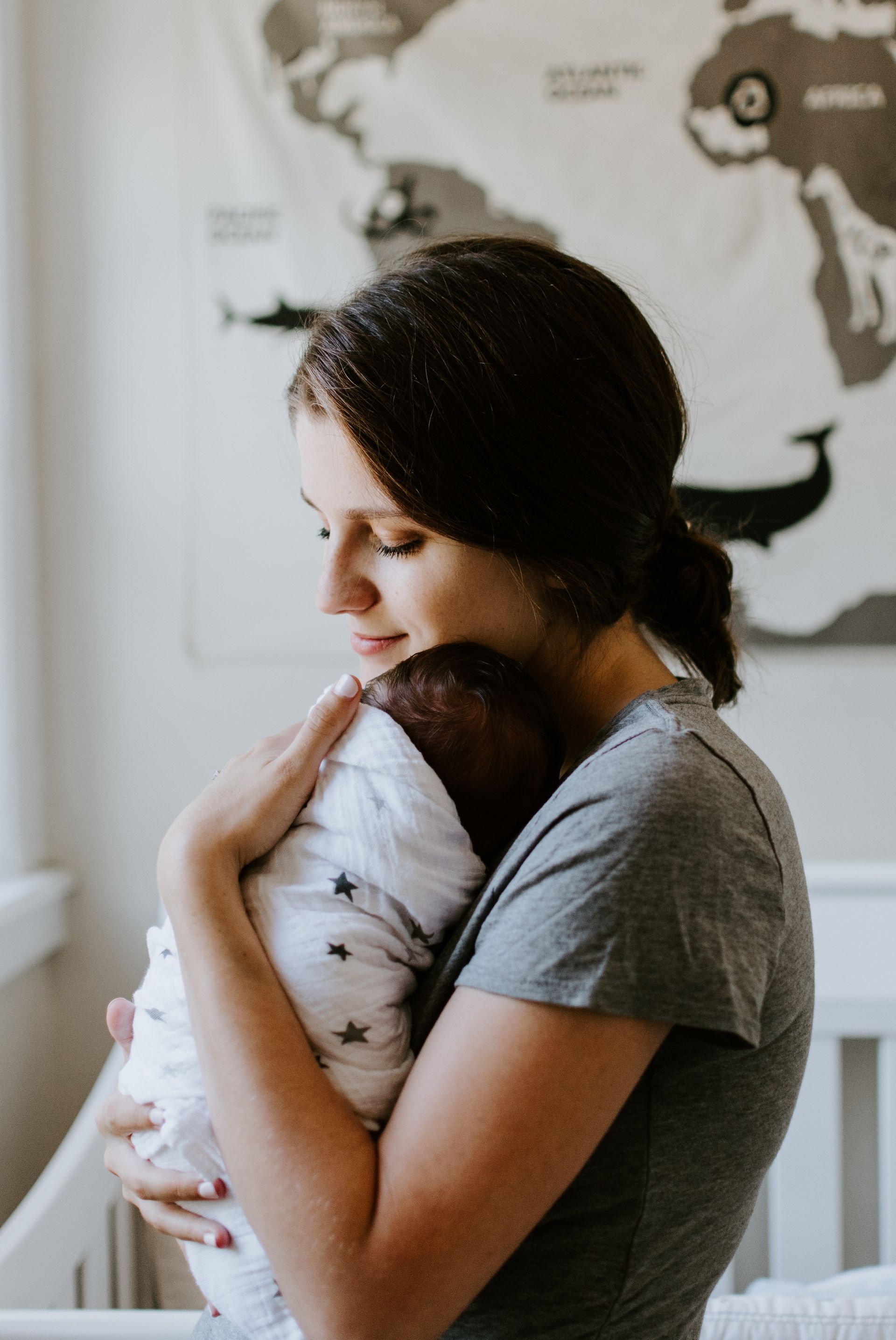 a woman is holding a baby in her arms in a nursery .