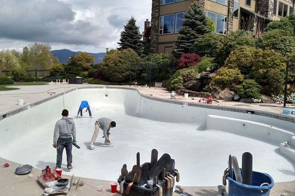 A group of men are working on a swimming pool.