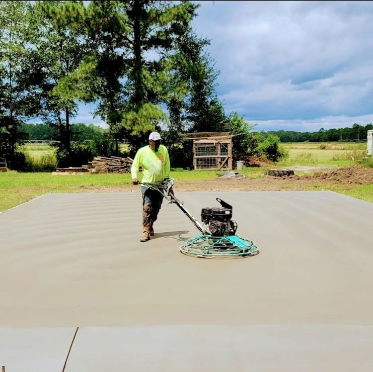 A man is using a machine to level a concrete driveway.