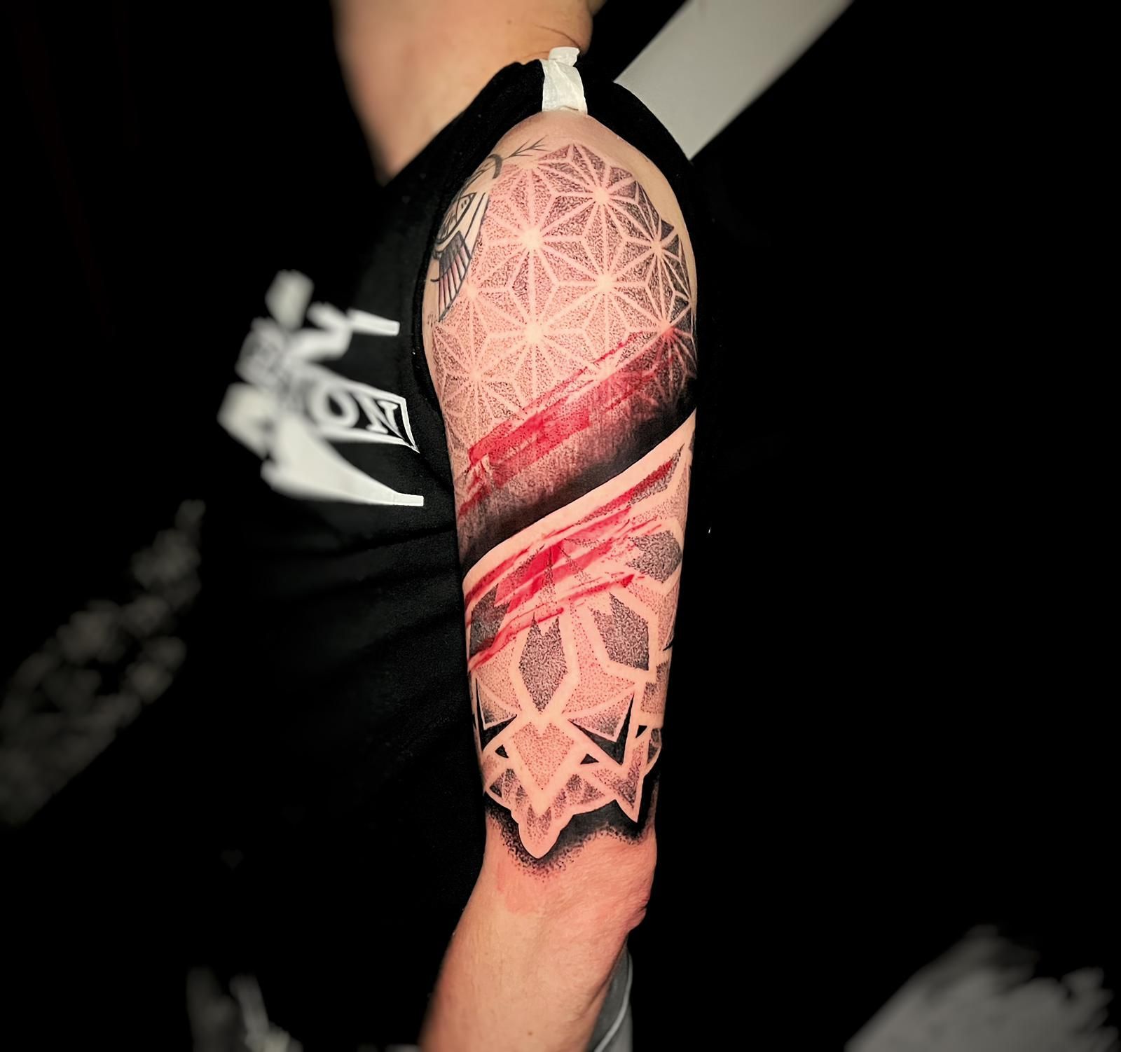 tatuaggio mandala rosso e nero braccio