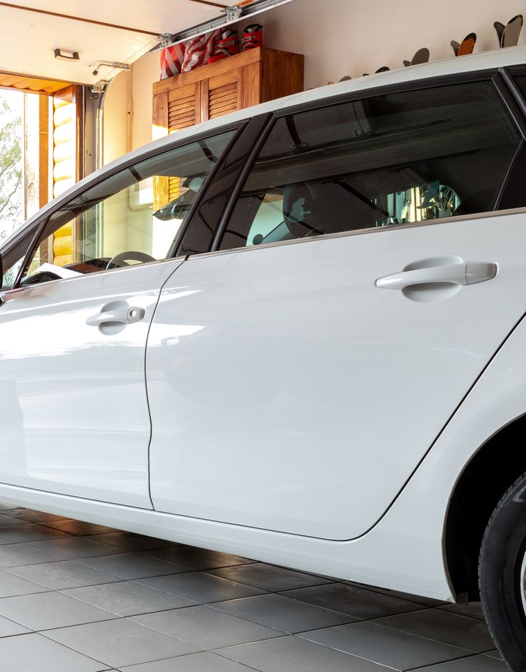White Car Parked Inside a Garage; Door and Window Visible — O'Brien Carglass & Tinting in Atherton, QLD