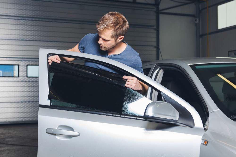Applying Tinting Foil onto A Car Window in A Workshop  — O'Brien Carglass & Tinting in Mareeba, QLD