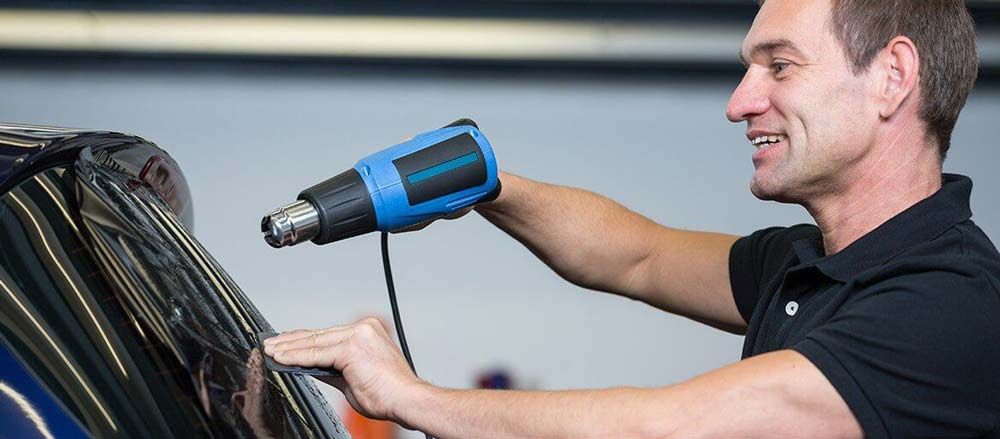 Worker Happily Installs Window Tint — O'Brien Carglass & Tinting in Mareeba, QLD