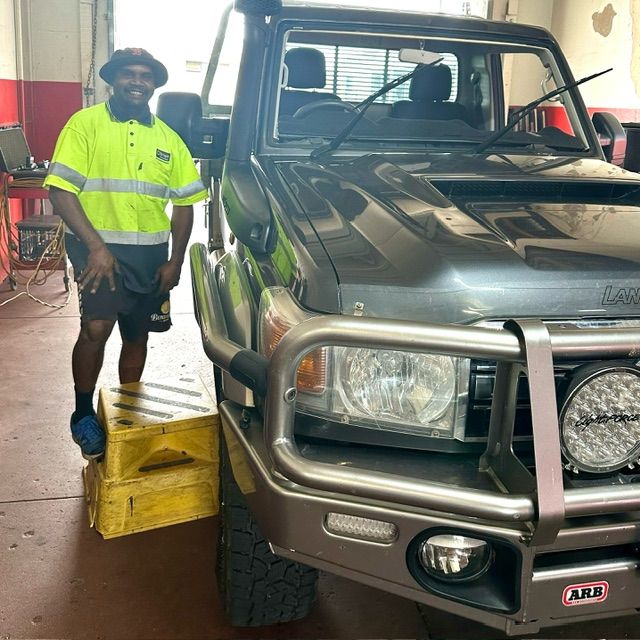 A Man in a Yellow Shirt is Standing Next to a Truck That Says Arb on the Front — O'Brien Carglass & Tinting in Mareeba, QLD