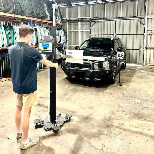 Worker Applying Tinting Foil onto Car Window — O'Brien Carglass & Tinting in Mareeba, QLD