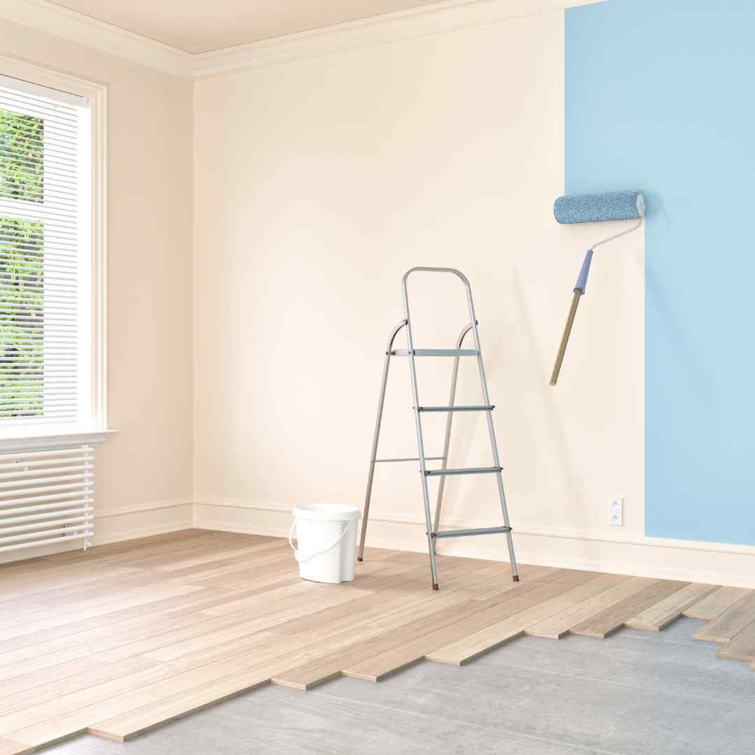 Spacious open-concept living room with gray sectional, rug, and coffee table, leading to kitchen and dining area.