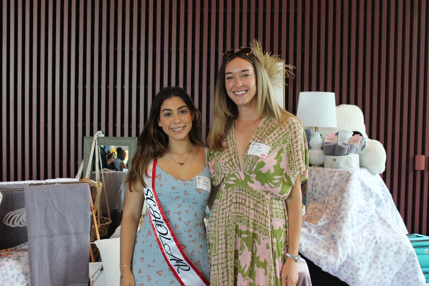 Two women are posing for a picture together in a room.