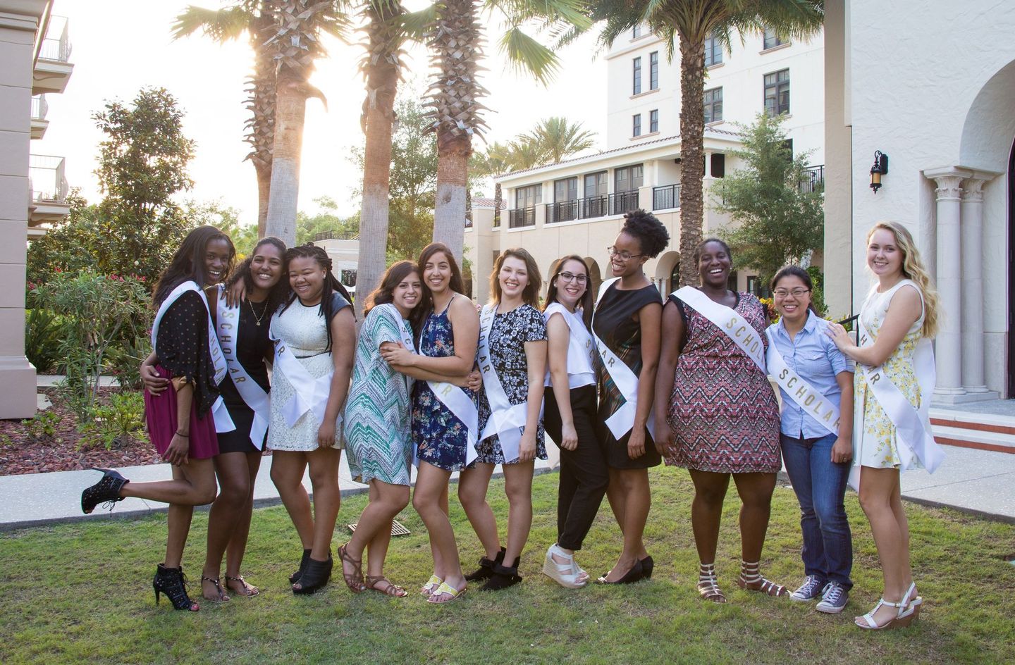 A group of women are posing for a picture in front of a building.