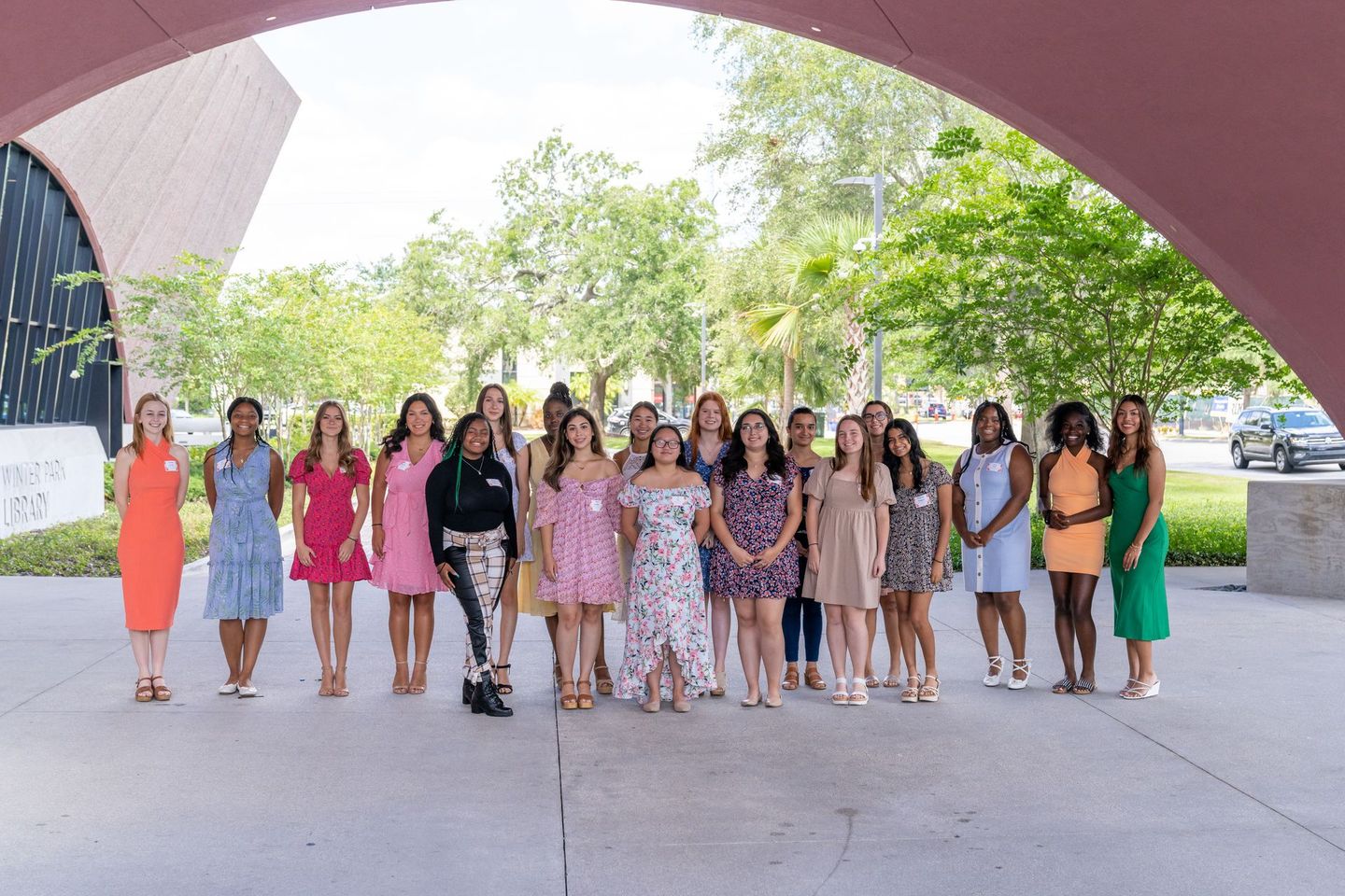 A group of women are posing for a picture under an archway.