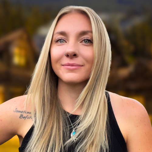 A woman with long blonde hair and a tattoo on her arm