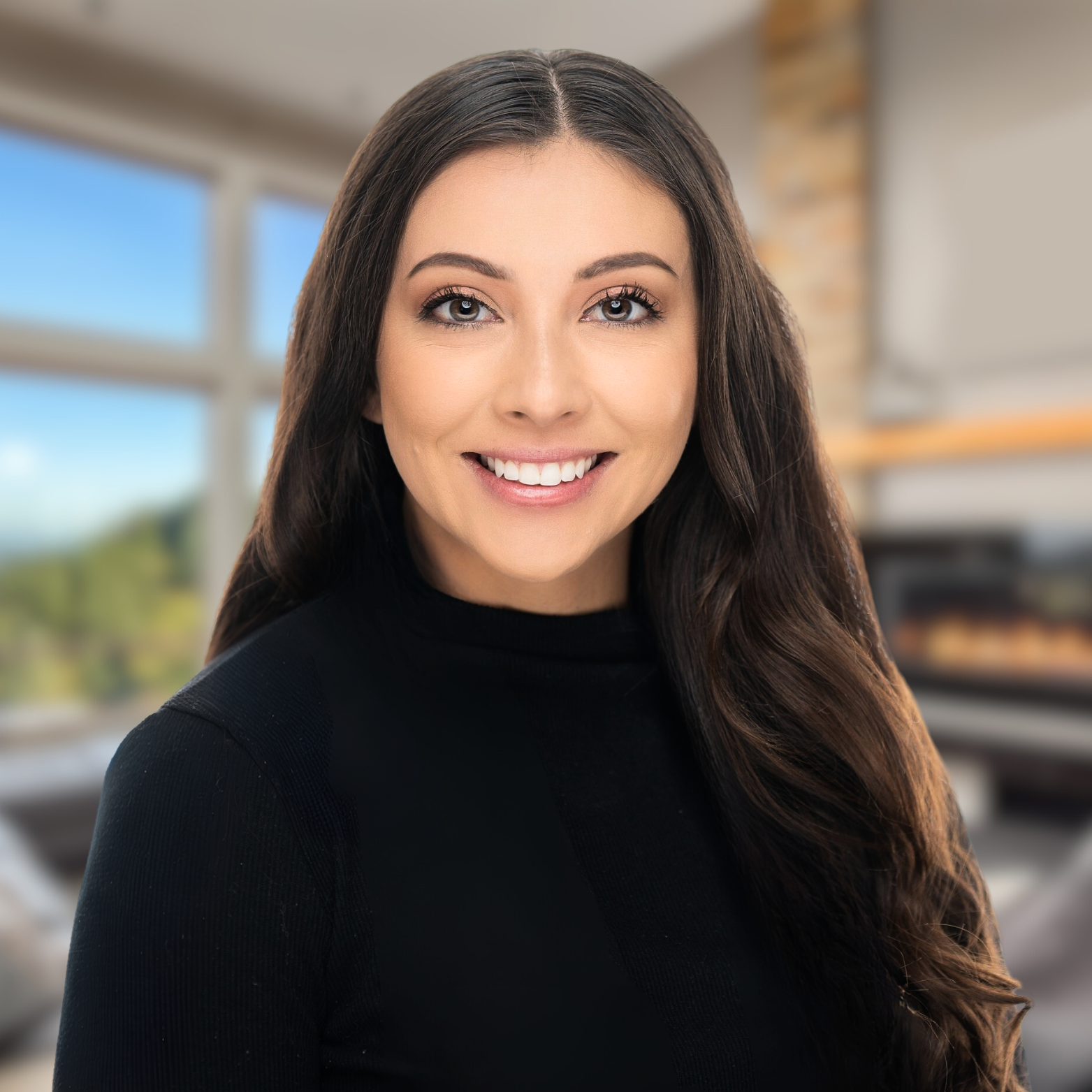The woman is wearing a black sweater and smiling for the camera.