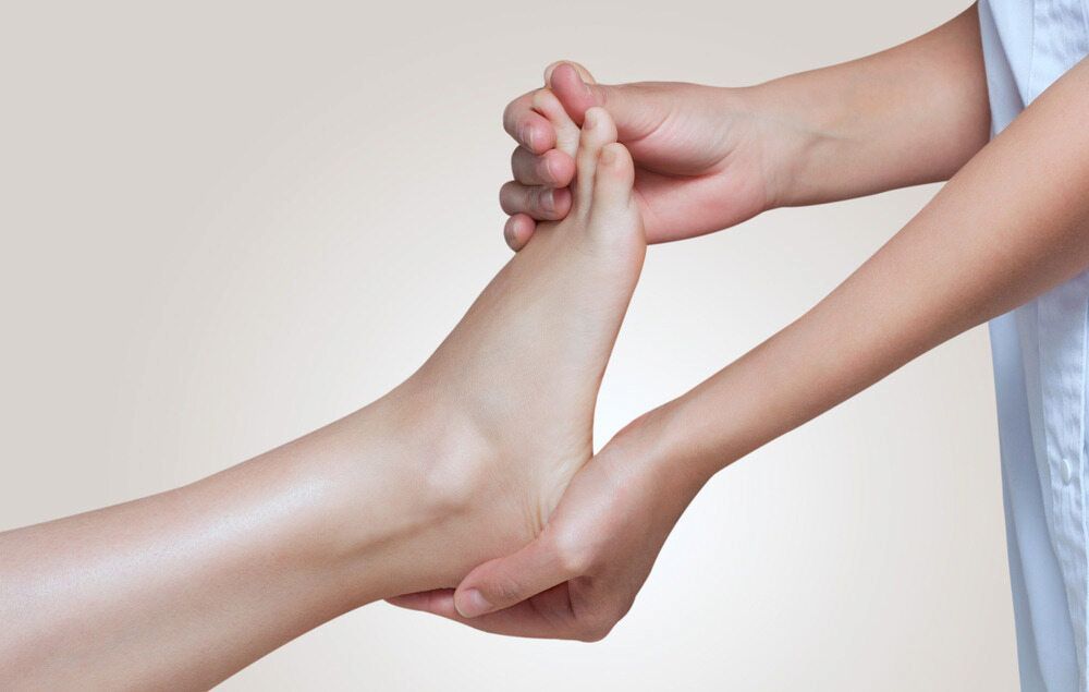 A Woman Is Giving A Foot Massage To Another Woman — Lake Macquarie Podiatry in Belmont, NSW