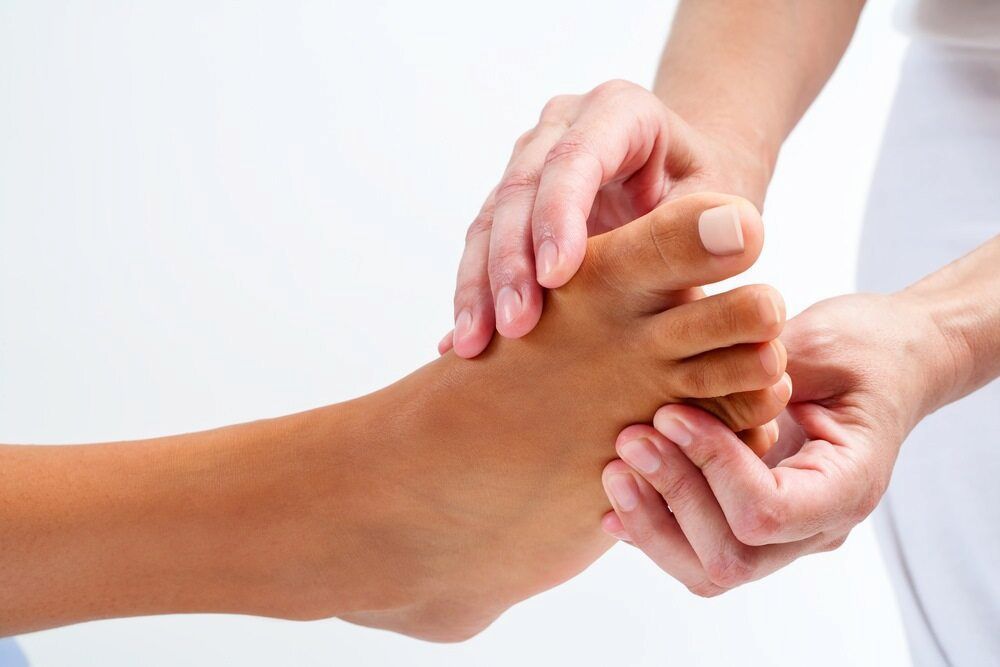 A Person Is Giving A Foot Massage To Another Person — Lake Macquarie Podiatry in Belmont, NSW