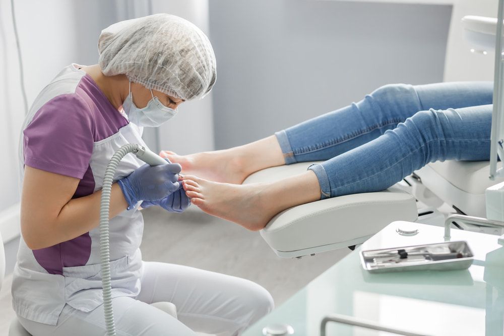 A Woman Is Getting Her Feet Examined By A Podiatrist — Lake Macquarie Podiatry in Rathmines, NSW