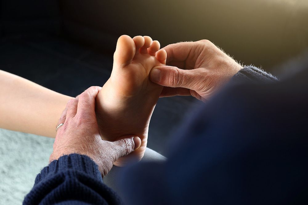 A Person Is Giving A Child A Foot Massage — Lake Macquarie Podiatry in Belmont, NSW