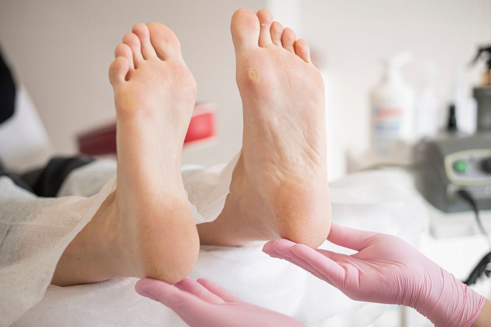 A Woman Is Getting Her Feet Examined By A Podiatrist — Lake Macquarie Podiatry in Swansea, NSW