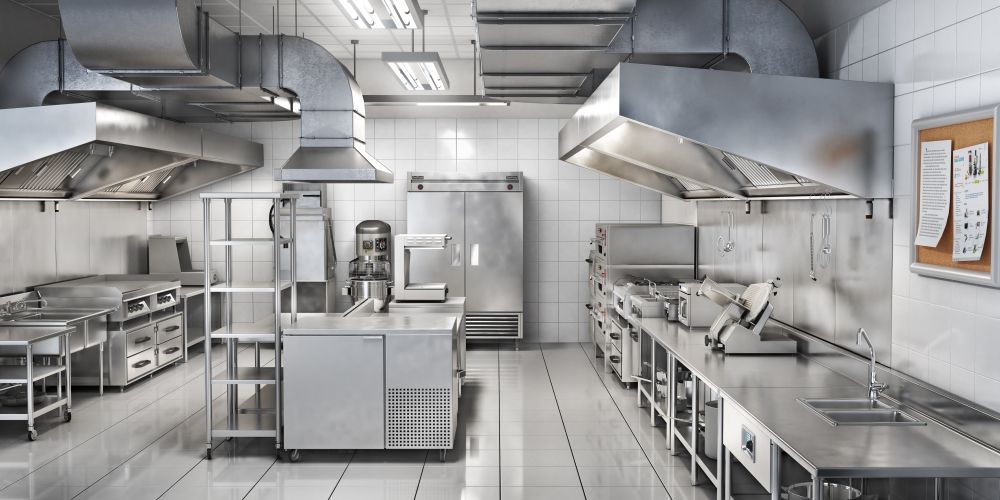 A large commercial kitchen with a lot of stainless steel appliances  — Gastech Plumbing Services in Andergrove, QLD