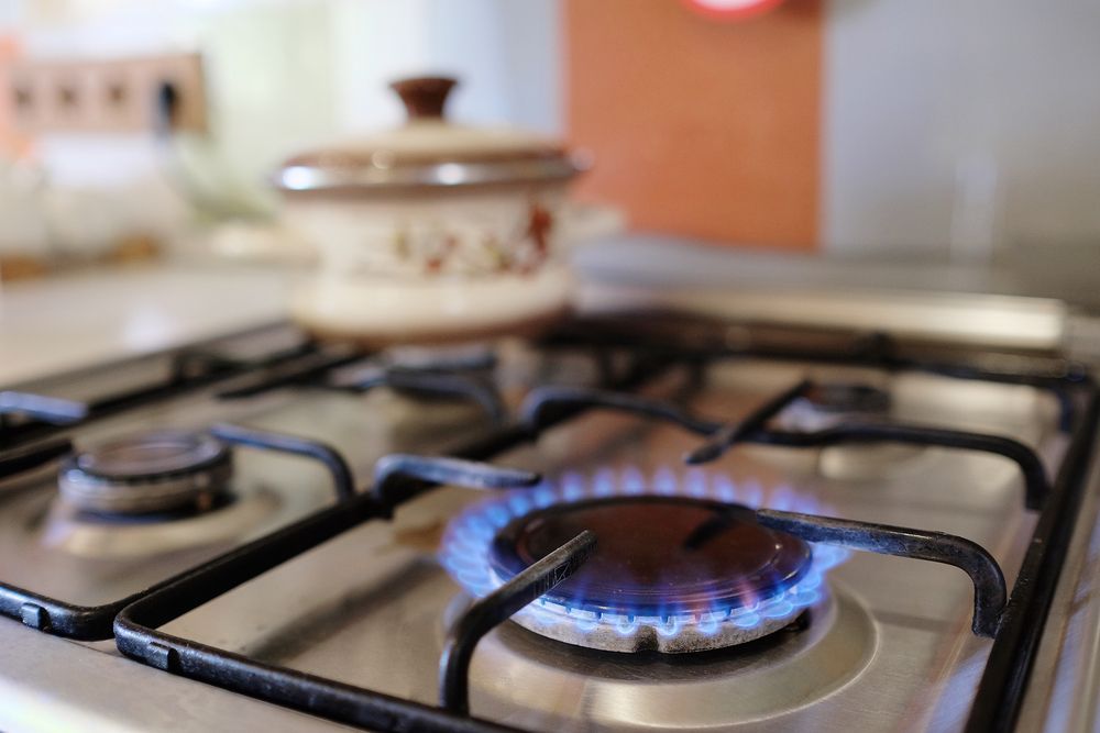 A close up of a gas stove with a pot in the background — Gastech Plumbing Services in Andergrove, QLD