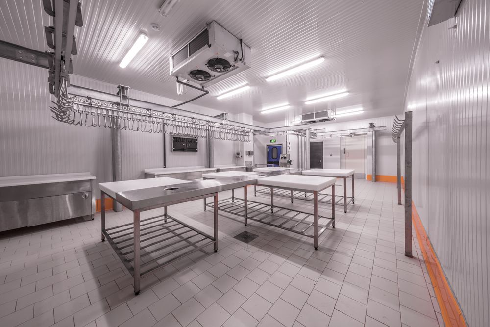 A Large Room With Stainless Steel Tables and a Ceiling Fan — Gastech Plumbing Services in Rural View, QLD