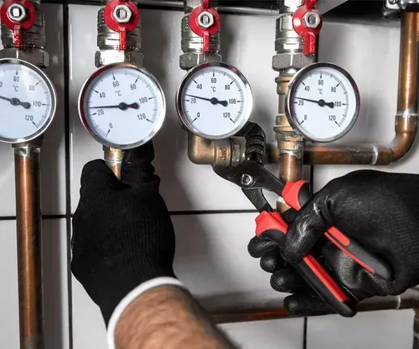 A Person is Working on a Pipe With a Pair of Pliers — Gastech Plumbing Services in Andergrove, QLD