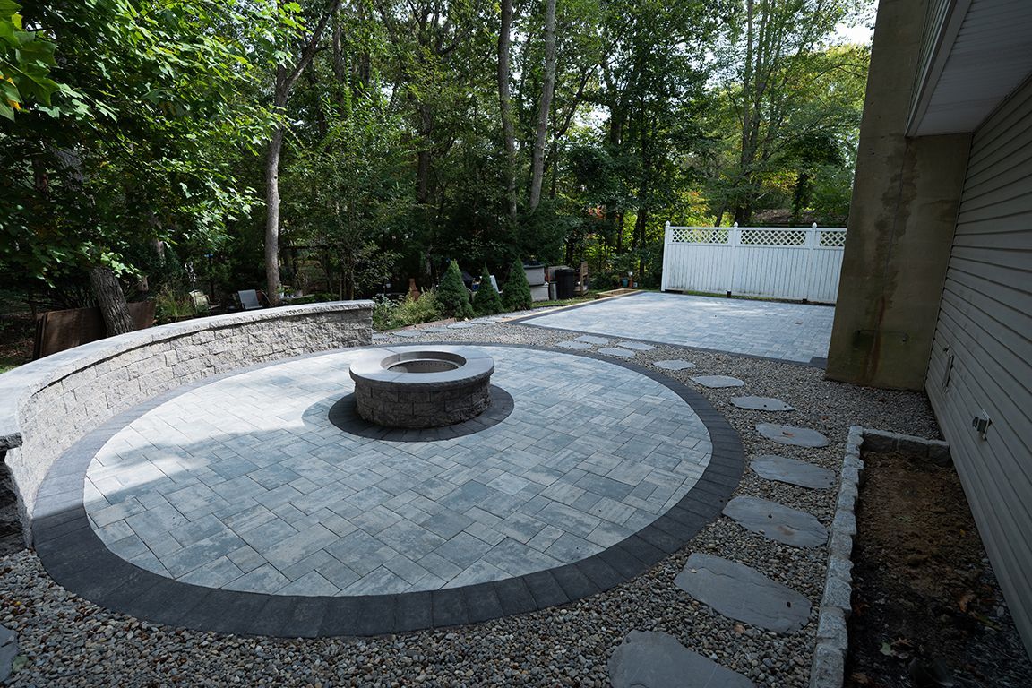 Circular paver patio with built-in fire pit and seating area
