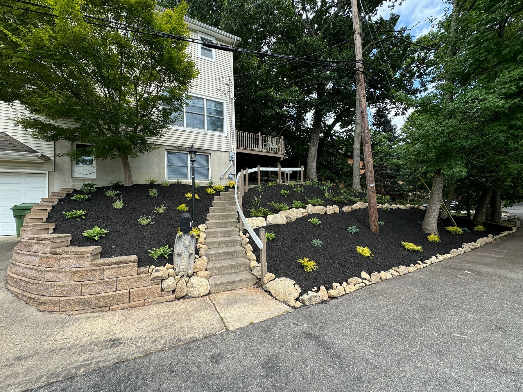 Stone retaining wall with steps and fresh landscape plantings