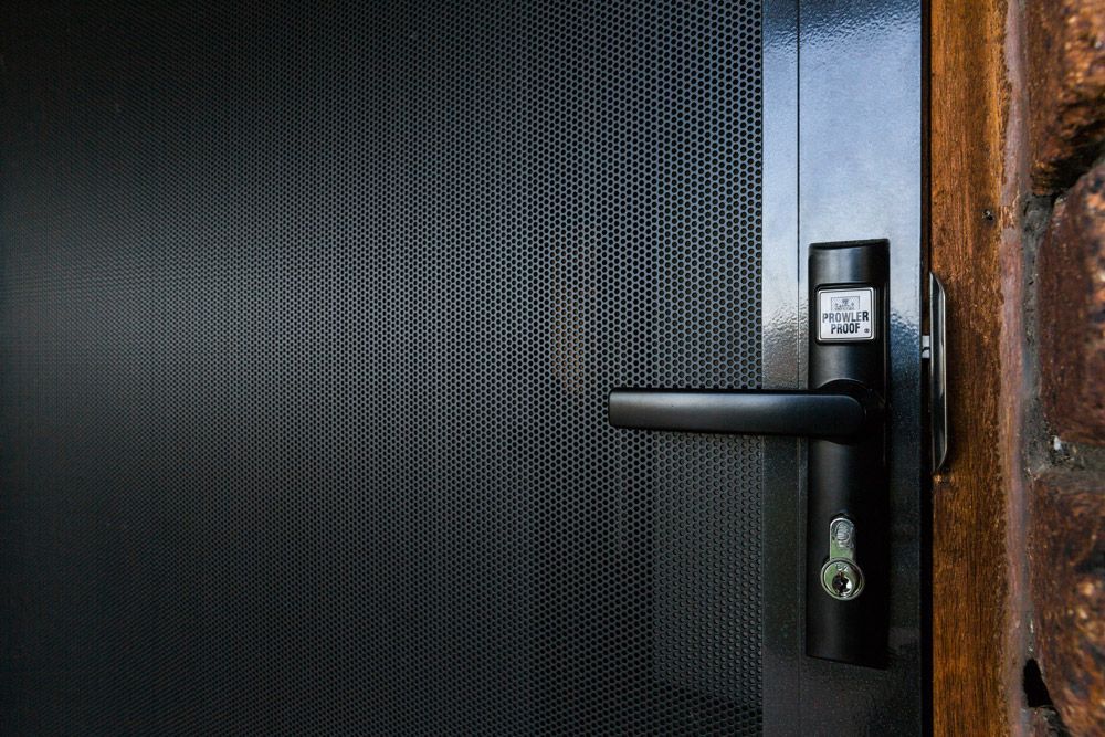 Family Eating at a Table, Screened Door Open to Interior With Stairs — All Security Screens & Repairs In Bungalow, QLD