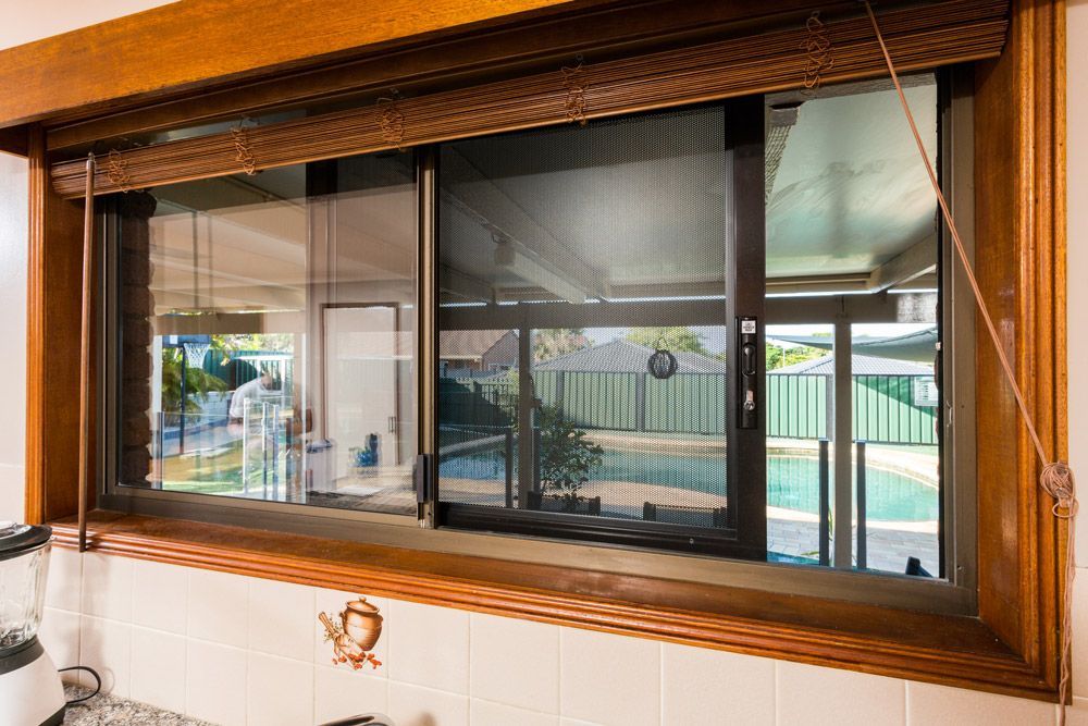 Sliding Glass Door With Grey Frame, Handles, and a Screen — All Security Screens & Repairs In Bungalow, QLD