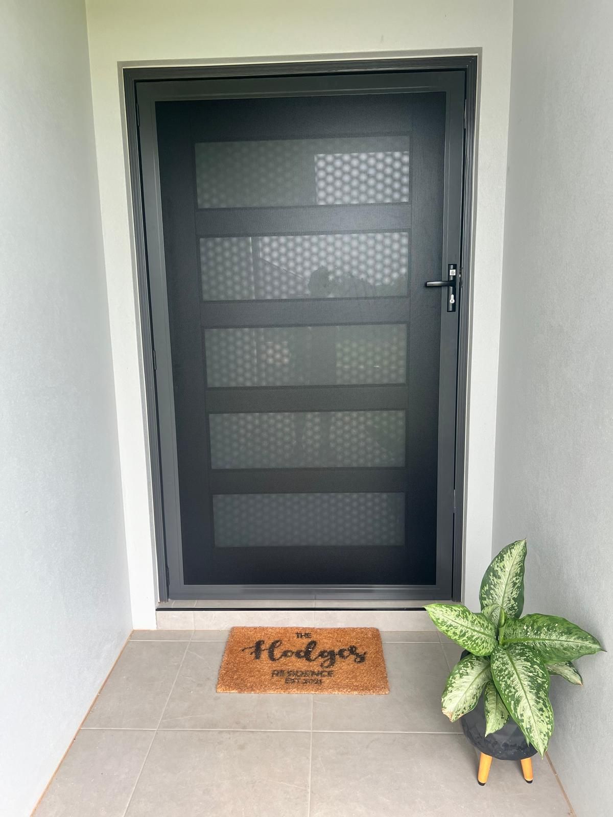 Black Security Door With Five Glass Panels, Welcome Mat — All Security Screens & Repairs In Bungalow, QLD