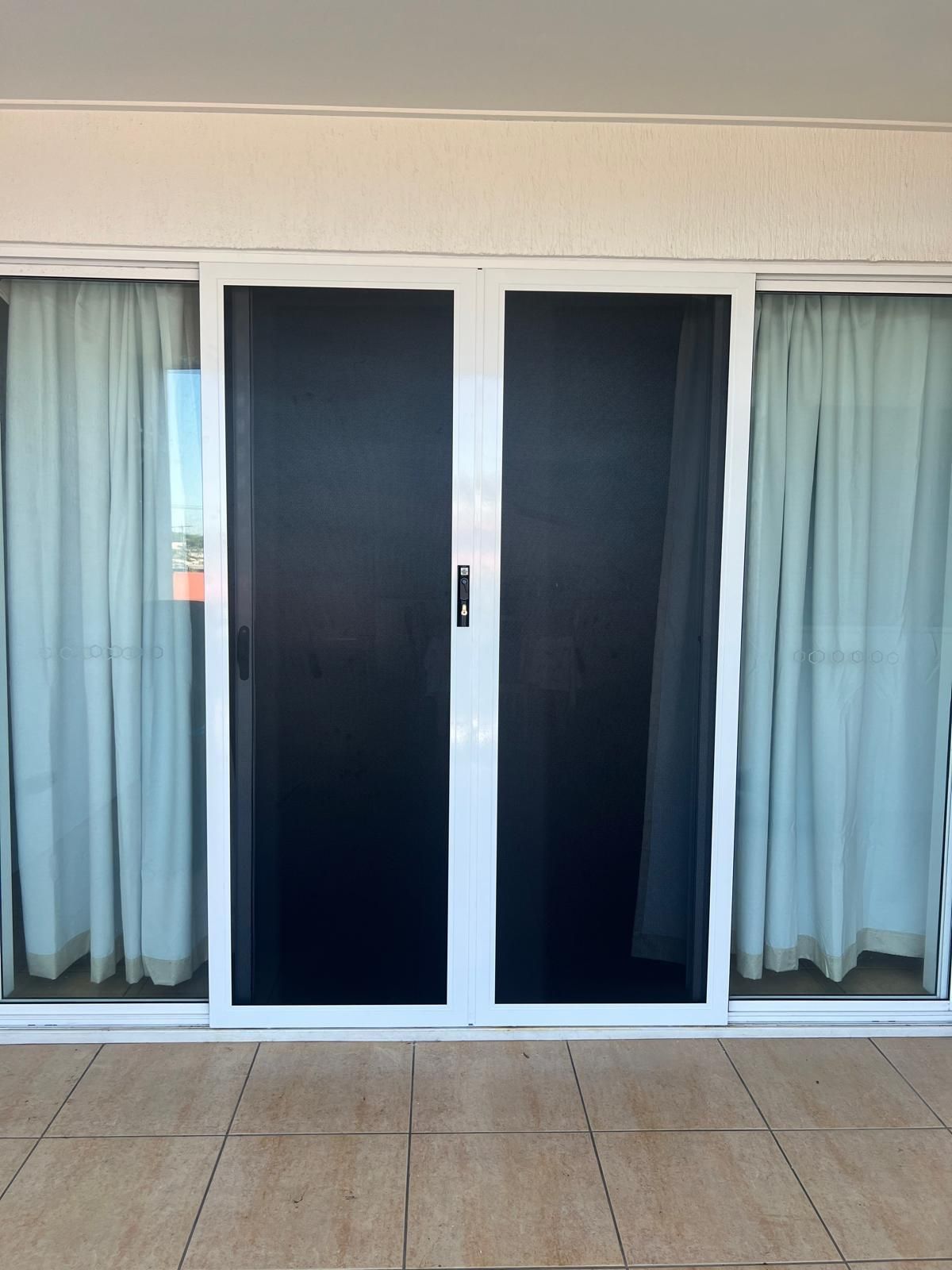 White-Framed Sliding Glass Doors With Black Screen and White Curtains — All Security Screens & Repairs In Bungalow, QLD