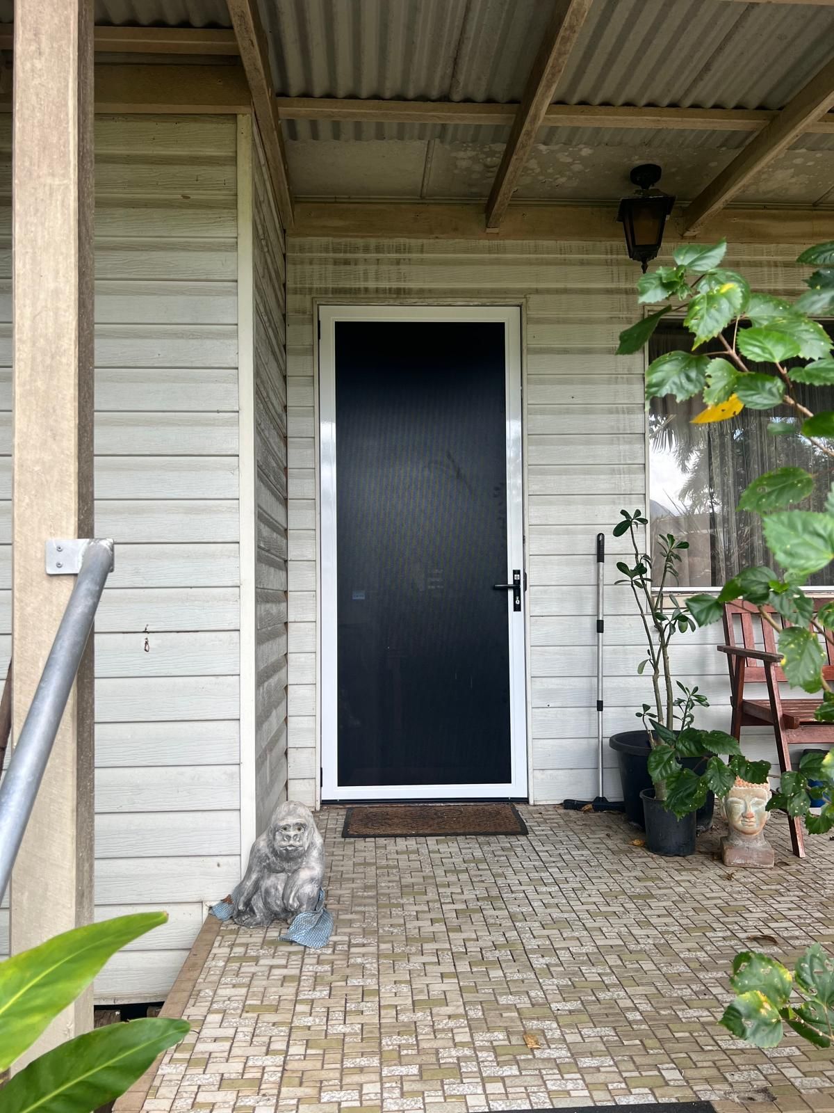 Black Front Door With White Trim, Covered Porch With Brick Tiles — All Security Screens & Repairs In Bungalow, QLD