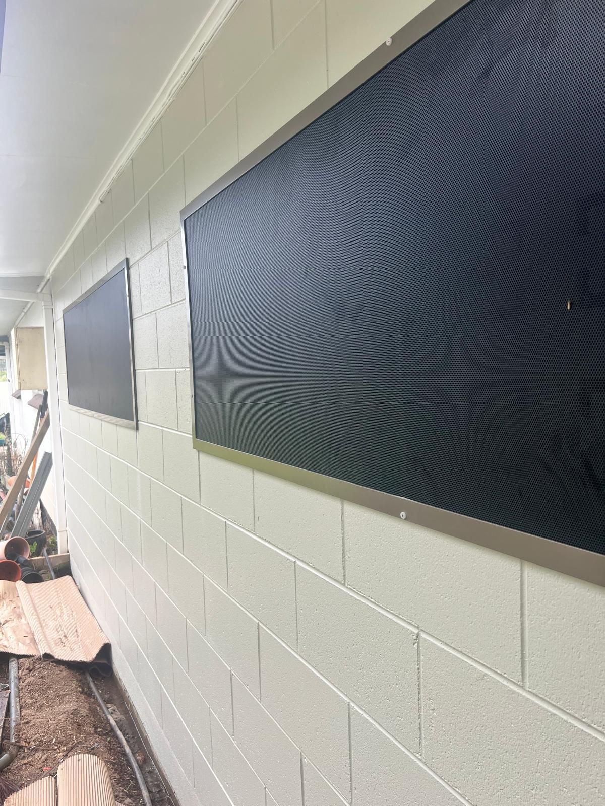 Two Black Rectangular Window Screens on a White Brick Wall — All Security Screens & Repairs In Bungalow, QLD