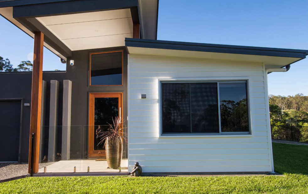 Bright Bedroom With Bed, Chairs, and Patio Door to an Outdoor Seating Area — All Security Screens & Repairs In Bungalow, QLD