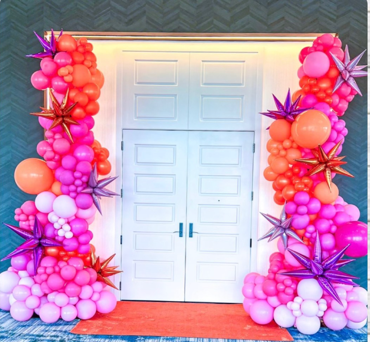 A door is decorated with pink and orange balloons