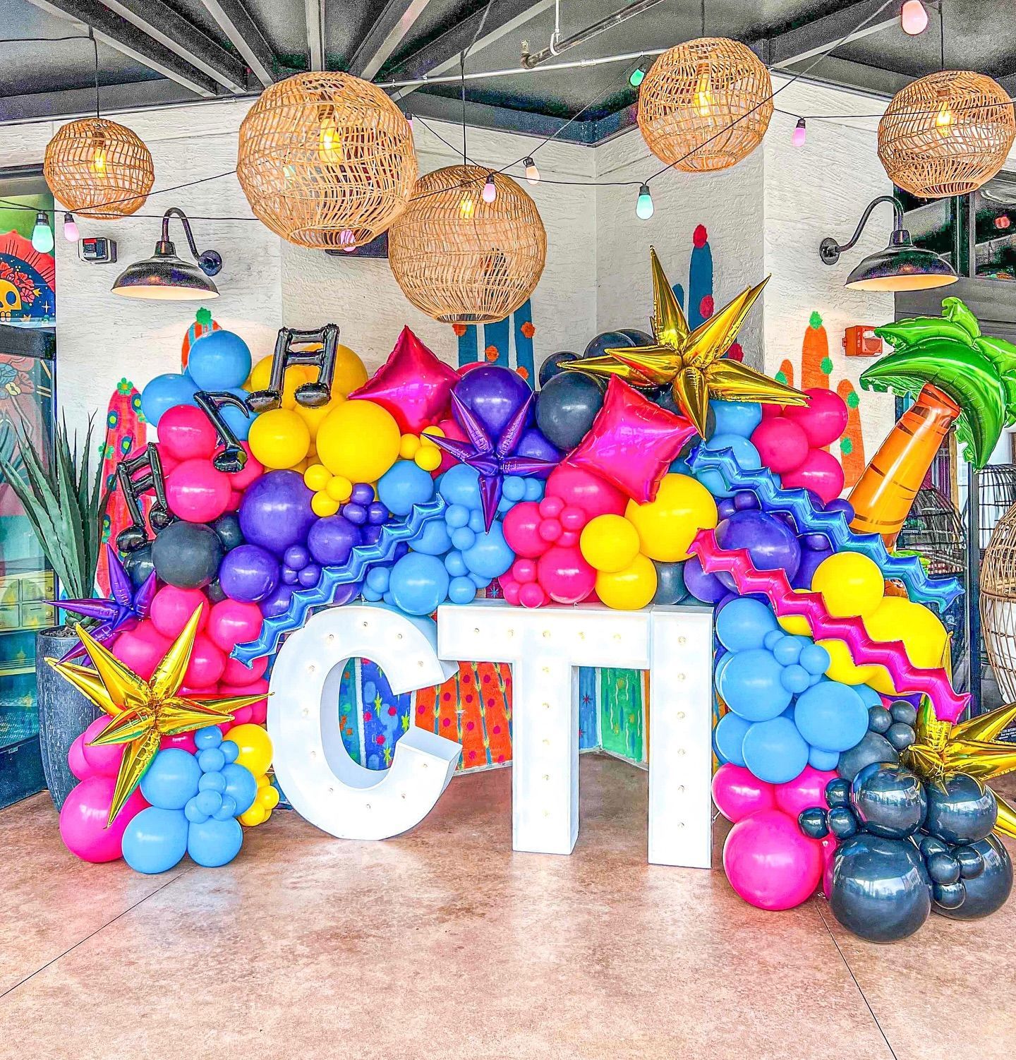 A room filled with colorful balloons and a large white letter cti.