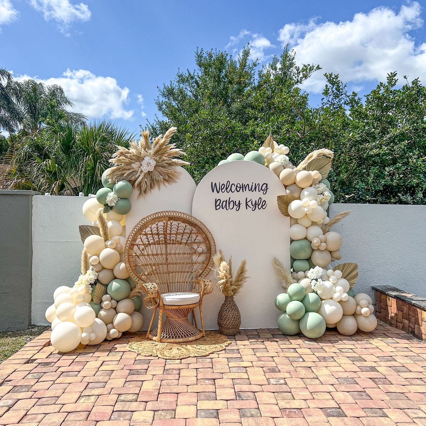 A wicker chair is sitting in front of a wall decorated with balloons.