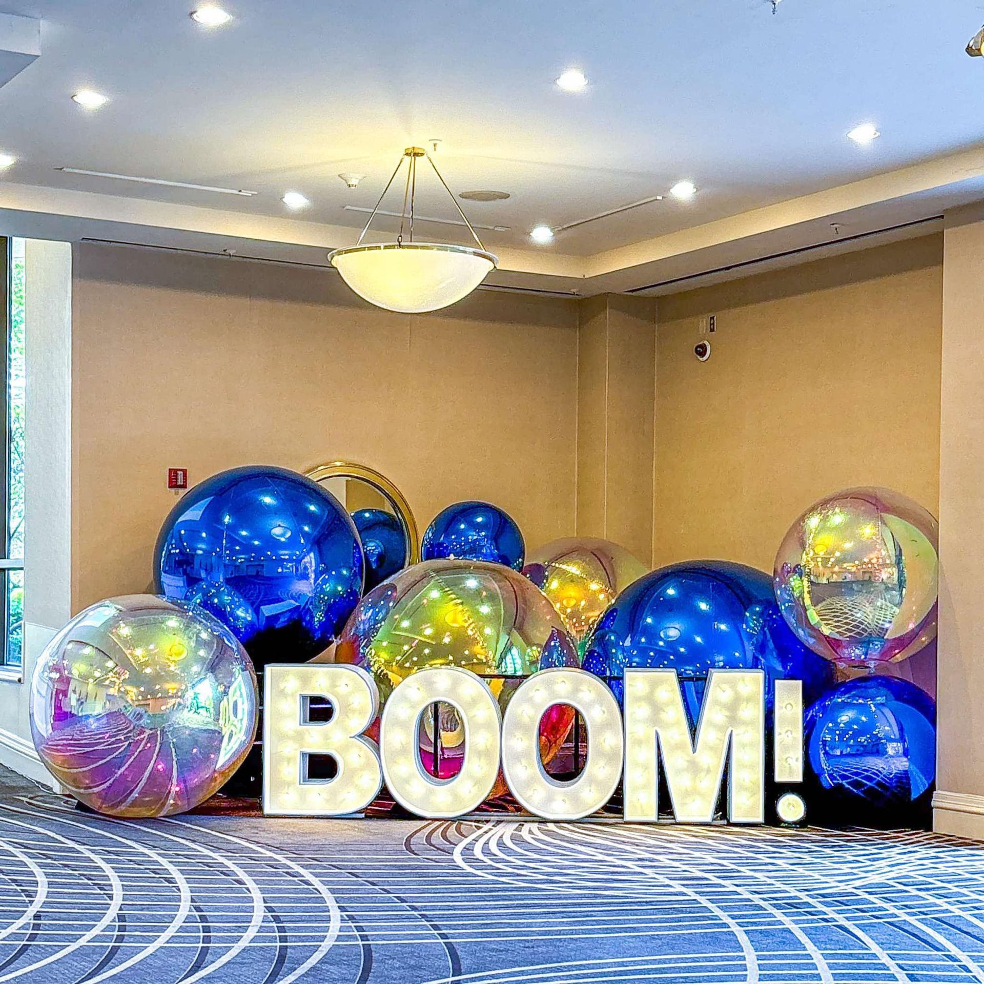 A room filled with balloons and a sign that says boom.