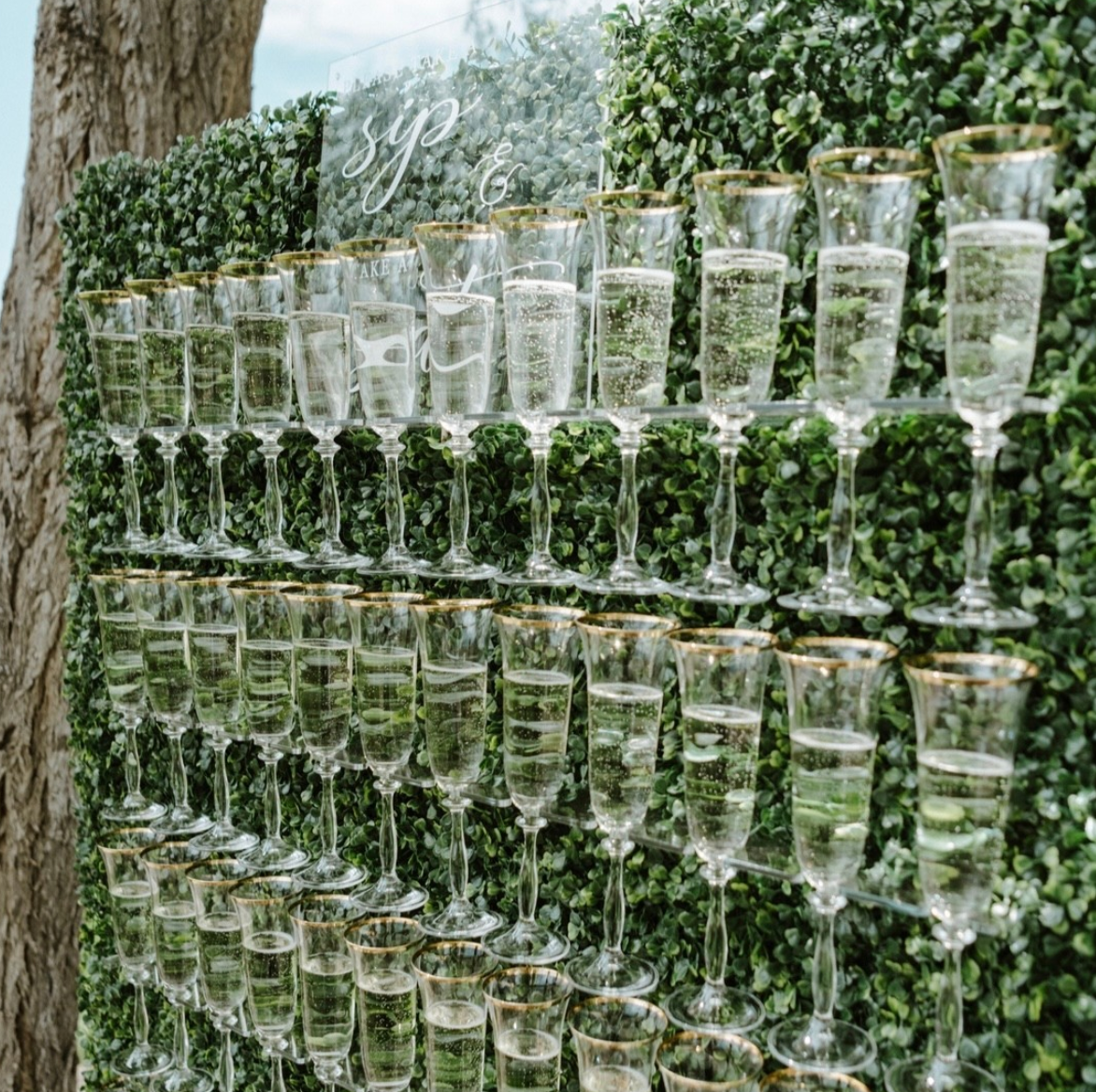 a wall of champagne glasses filled with water