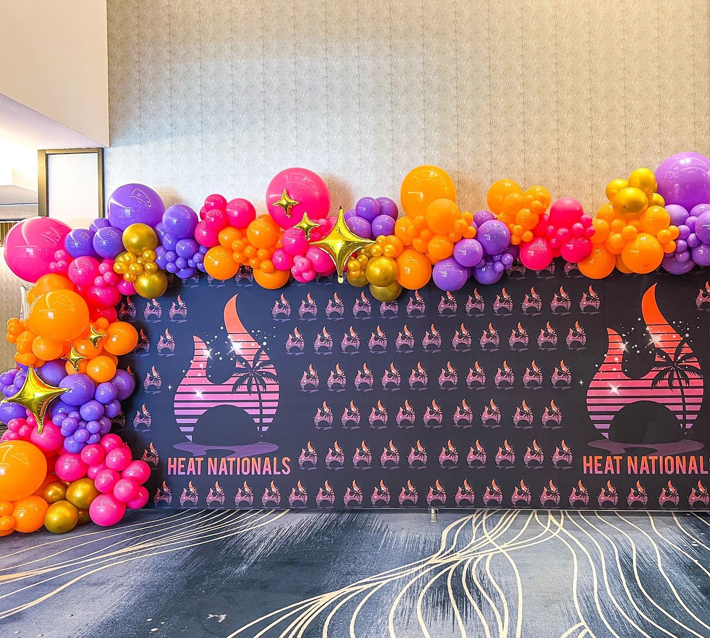 A wall decorated with balloons and a sign that says heat national