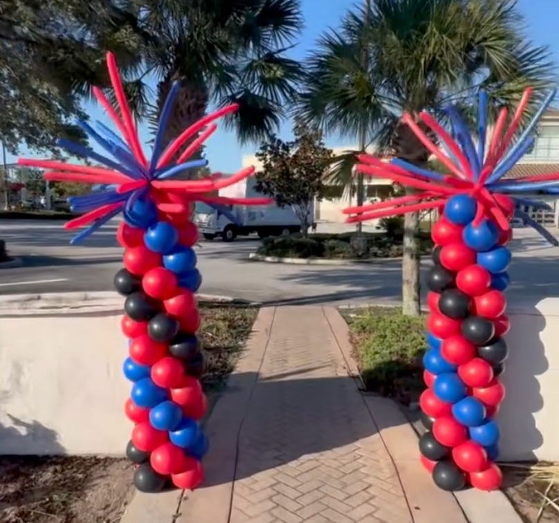 Two columns made of red and blue balloons on a sidewalk