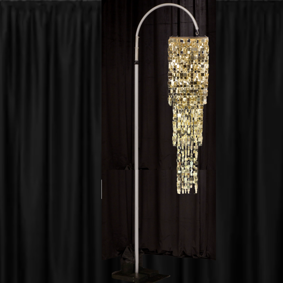 A lamp is hanging from a pole in front of a black curtain