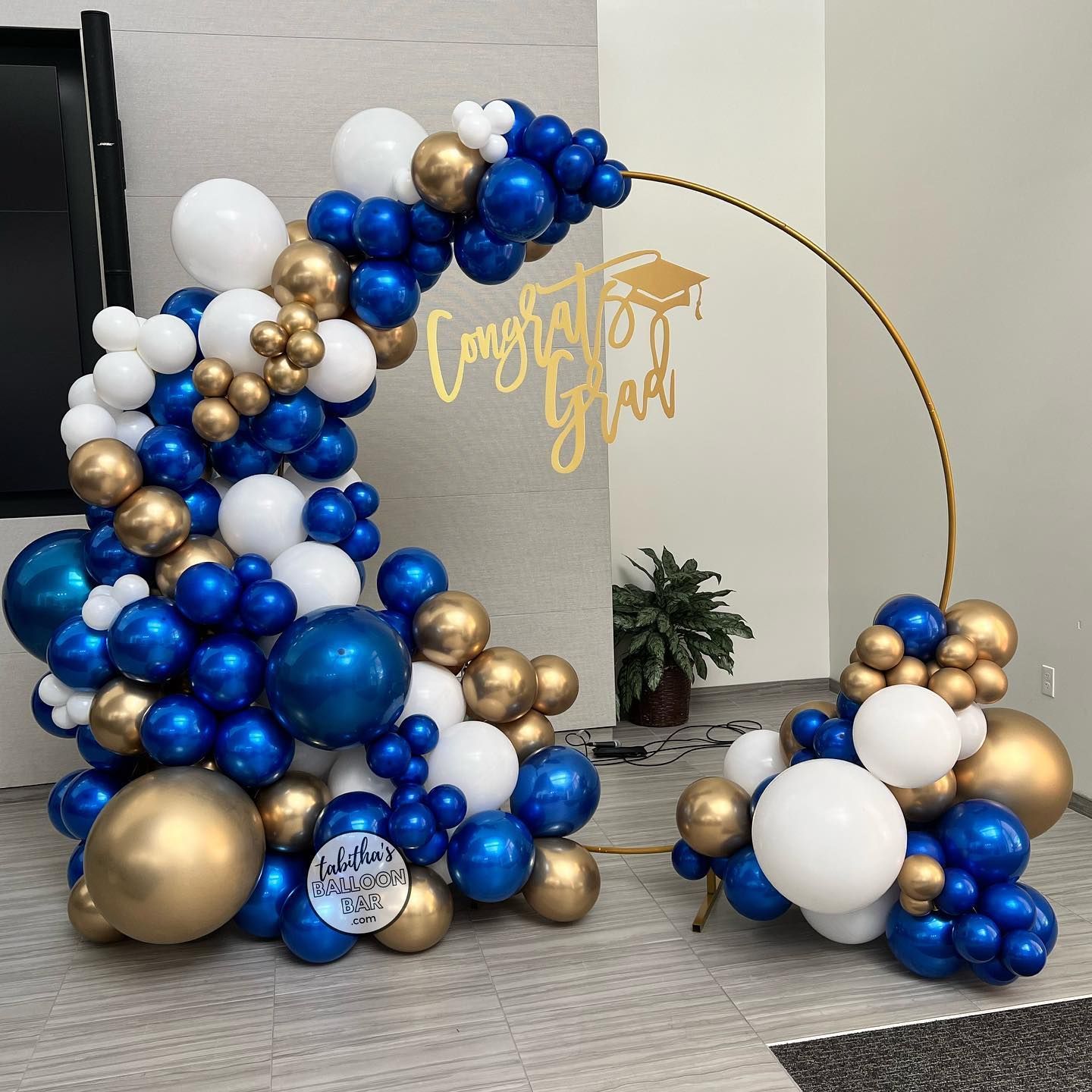 A bunch of blue and gold balloons are sitting on the floor.