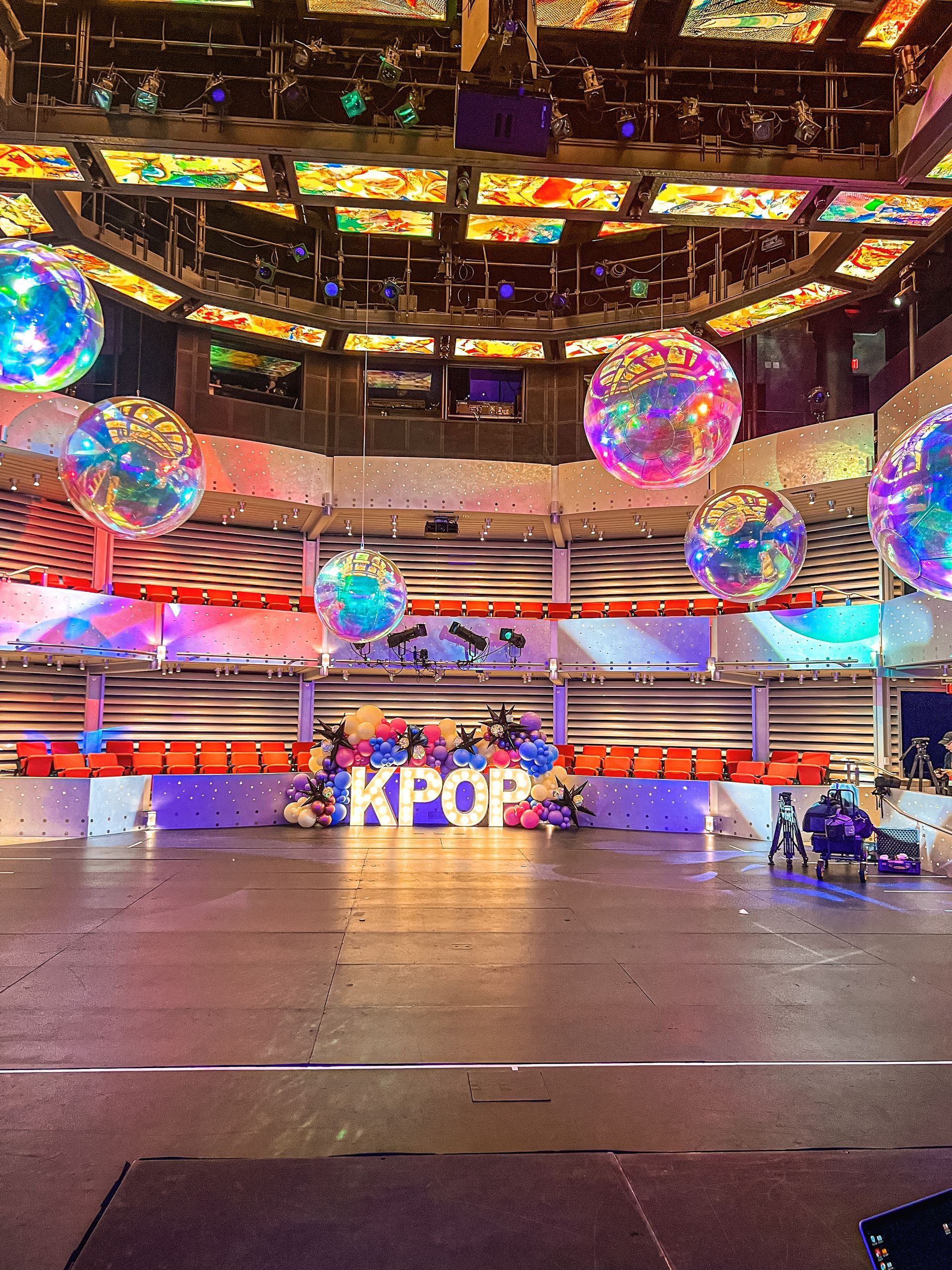 A large stadium filled with balloons and a sign that says kpop.